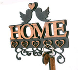 The LD Trade Wall Key Holder is a decorative home accessory that spells "HOME" with wooden letters and features two birds facing each other above a heart, beautifully capturing the essence of "home sweet home." Below this charming design are five heart-shaped hooks, providing an elegant solution to keep your keys organized.